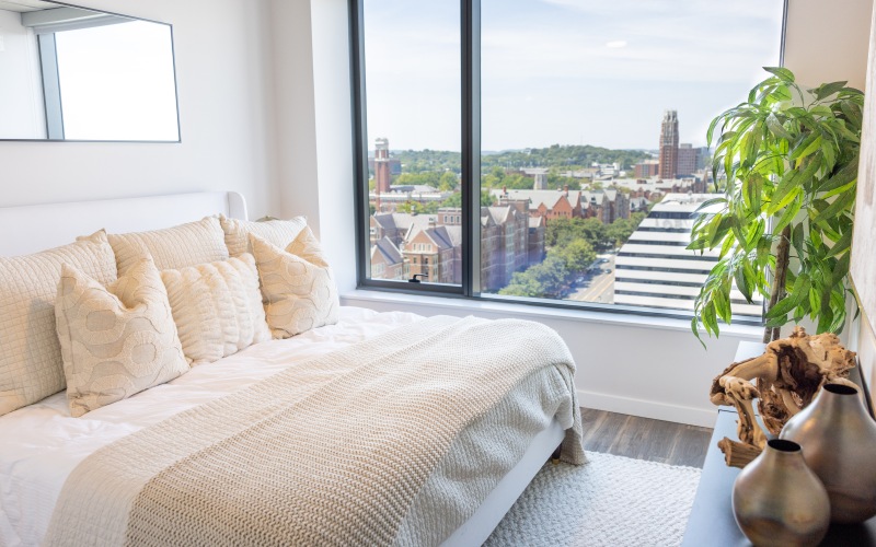 Bedroom with large window and city view